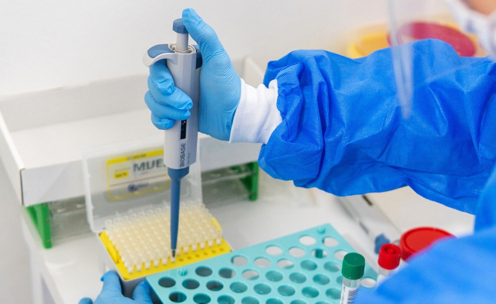 Profesional del laboratorio de biología molecular trabajando con una micropipeta
